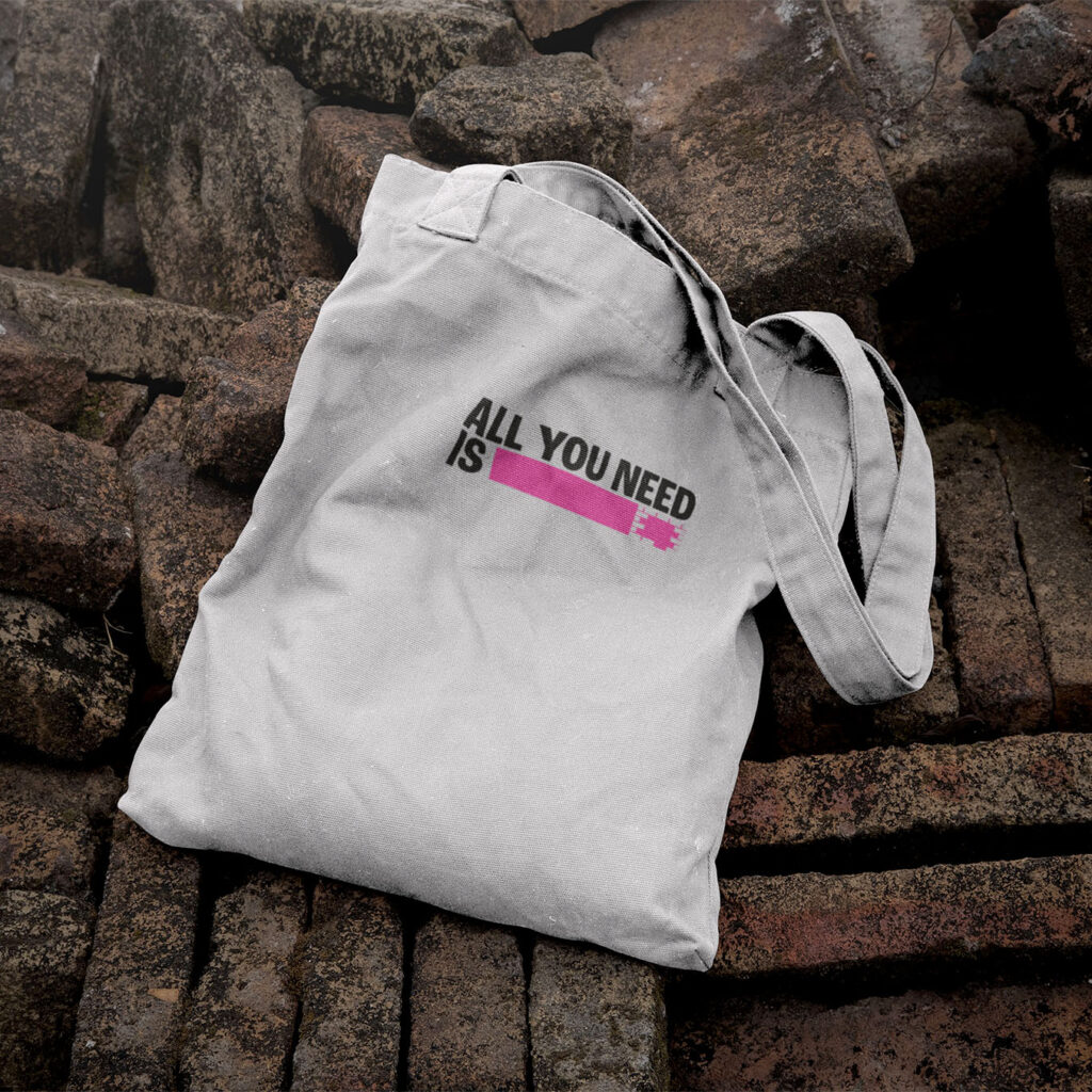 Projet Rose festival : tote bag avec écrit "all you need is" suivi d'un rectangle de briques rose (qui rappellent le logo du festival)